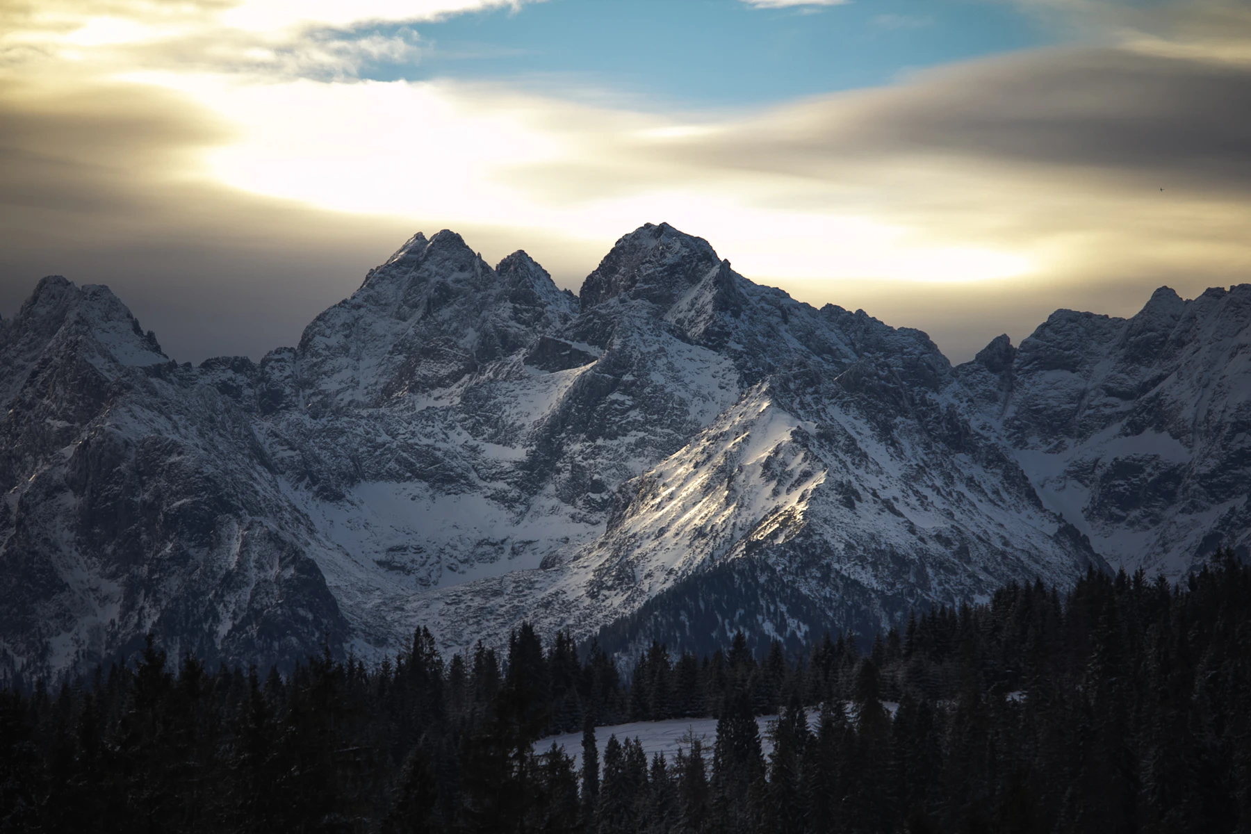 Ośnieżone Tatry pod zachmurzonym niebem